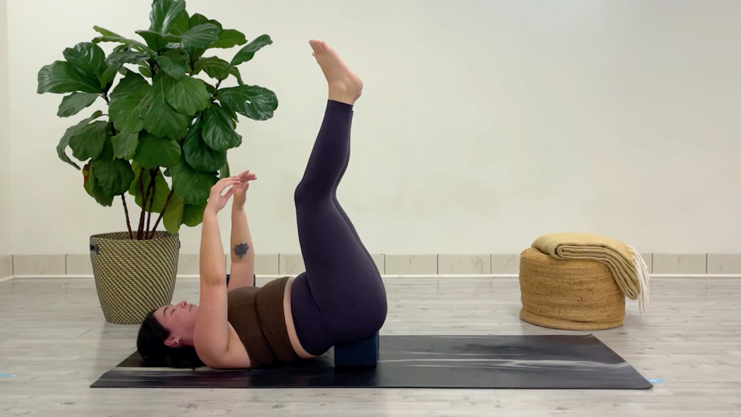 Yoga teacher Taylor Lorenz in Waterfall Pose, one of the best yoga poses for chilling out